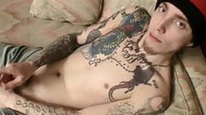 Tattooed young thug playing with his stiff dick on
