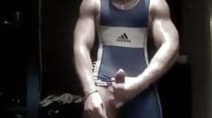 Muscled wrestler stroking big uncut cock in